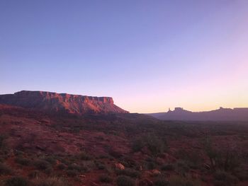 Scenic view of rocky mountains against clear sky during sunset