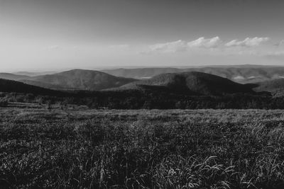 Scenic view of land and mountains against sky