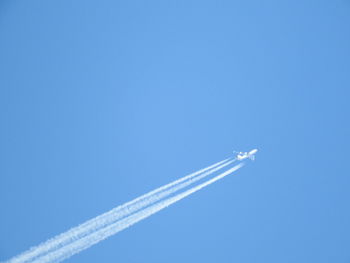 Low angle view of vapor trail against blue sky