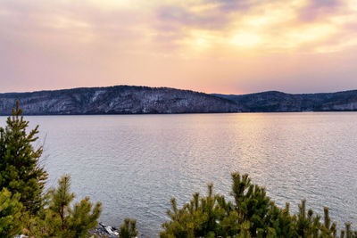 Scenic view of lake by mountains against sky