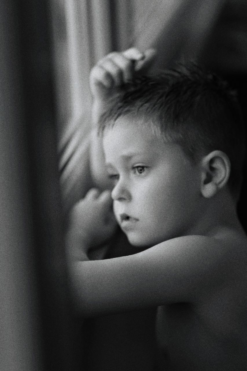 PORTRAIT OF BOY LOOKING AWAY AT HOME