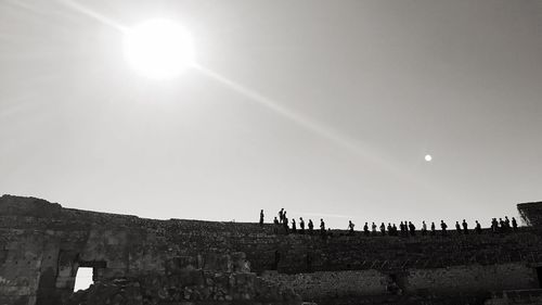 Low angle view of people at tarragona amphitheatre against sky in city