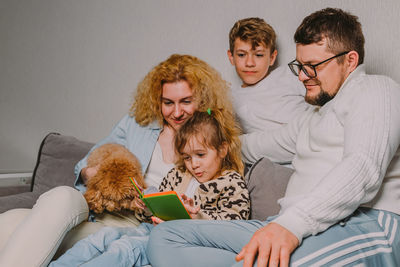 Female friends with teddy bear at home