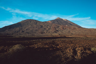 Scenic view of mountains against blue sky