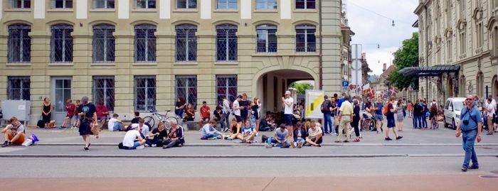 Panoramic view of people on sidewalk in city