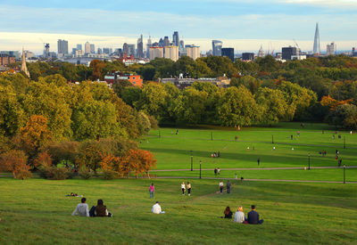 Scenic view of field against sky in city