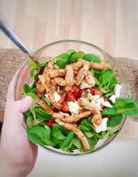 Close-up of hand holding salad in bowl