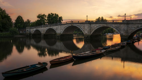 Bridge over river against sky during sunset