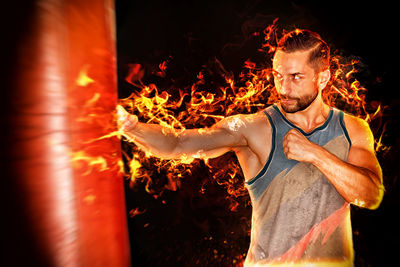 Digital composite image of man hitting punching bag