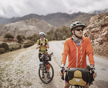 A male and female cyclist take a break on tizi n test pass, morocco