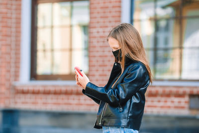 Girl wearing mask while using phone