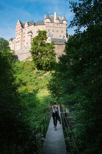 Rear view of people walking against building