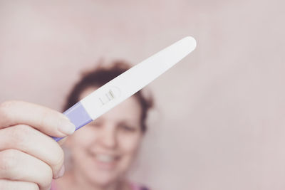 Close-up of woman hand holding pregnancy test