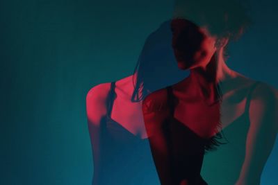 Double exposure image of woman standing against gray background