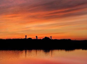 Scenic view of lake against orange sky