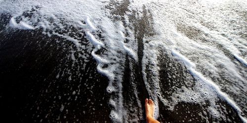 High angle view of foot in moving water