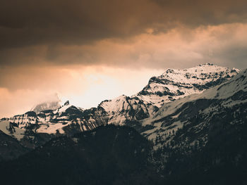 Scenic view of snowcapped mountains against sky during sunset