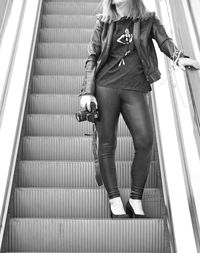 Low angle view of woman standing on escalator