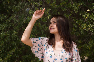 Beautiful young woman with arms raised