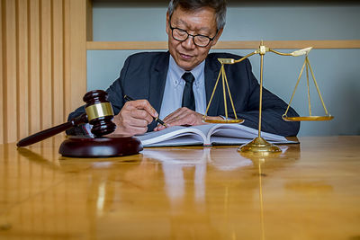 Man looking at camera while sitting on table