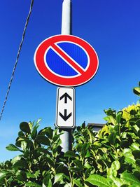 Low angle view of road sign against blue sky