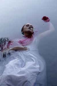 High angle view of dead young woman floating in water