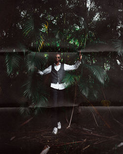 Full length of young man standing by tree