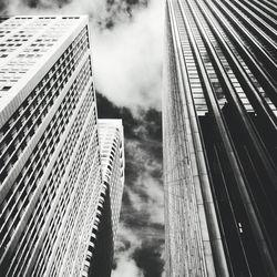 Low angle view of modern building against cloudy sky