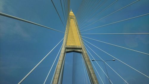 Low angle view of suspension bridge against clear blue sky