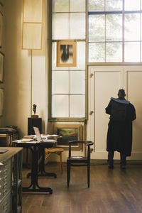 Rear view of woman sitting on chair at home