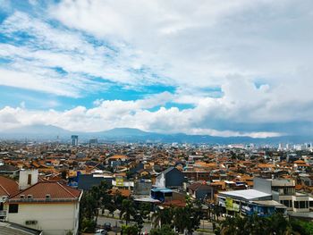 View of cityscape against cloudy sky