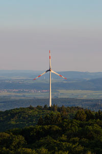 Windmills on landscape against sky