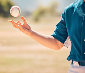 Midsection of baseball with ball on field