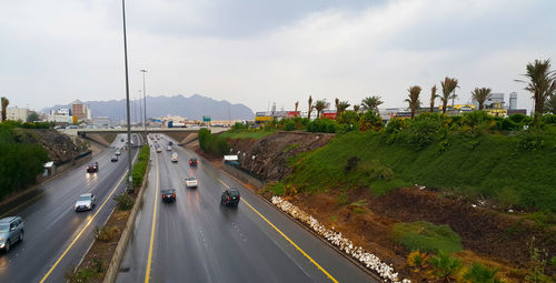 Cars on road in city against sky