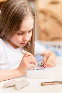 Felt wool craft by handmade needle. kid girl artisan hand makes a creative toy made of sheep hair