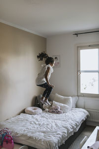 Girl jumping on bed