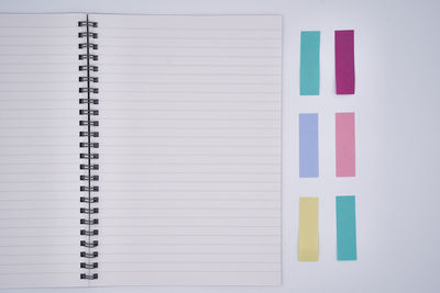 Directly above of spiral notebook with adhesive notes on gray background