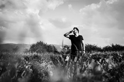 Man standing amidst plants against sky