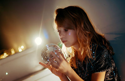 Close-up of young woman drinking water at home