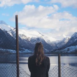 Rear view of woman standing on snow covered mountain