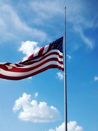 Low angle view of flag against blue sky