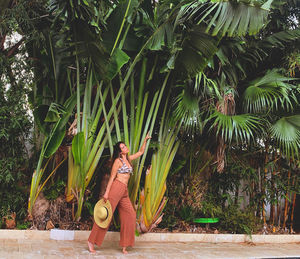 Young woman sitting on palm tree
