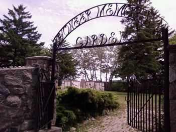 Gate on trees against sky