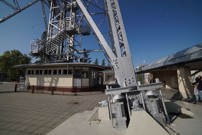 Low angle view of crane against clear blue sky