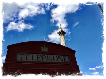 Low angle view of sign board against blue sky