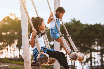 Sisters swinging at playground