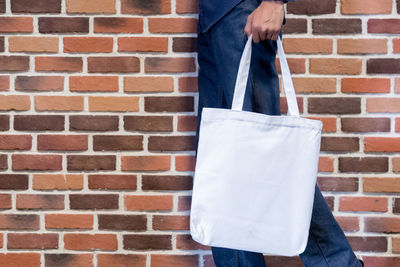 Low section of person standing against brick wall