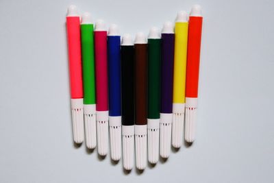 Close-up of colored pencils over white background