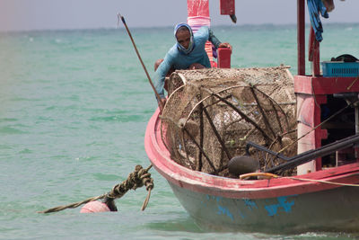 Men fishing in boat on sea