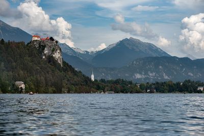 Scenic view of lake by mountains against sky